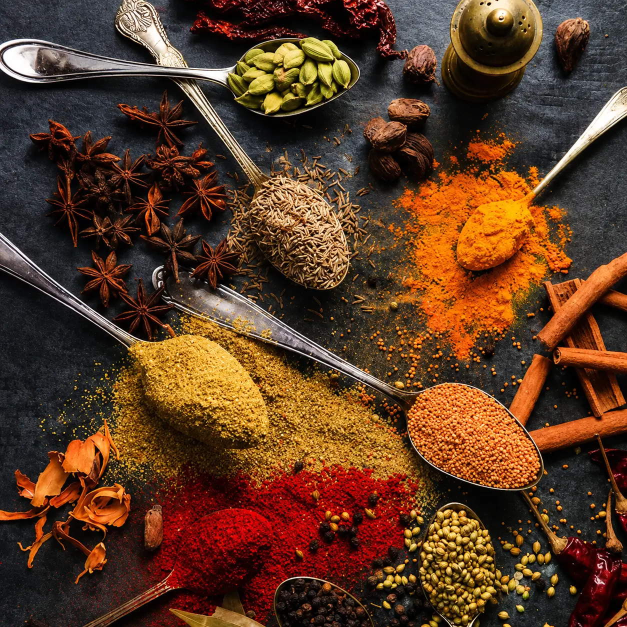 Chefs preparing spices in a traditional kitchen setting