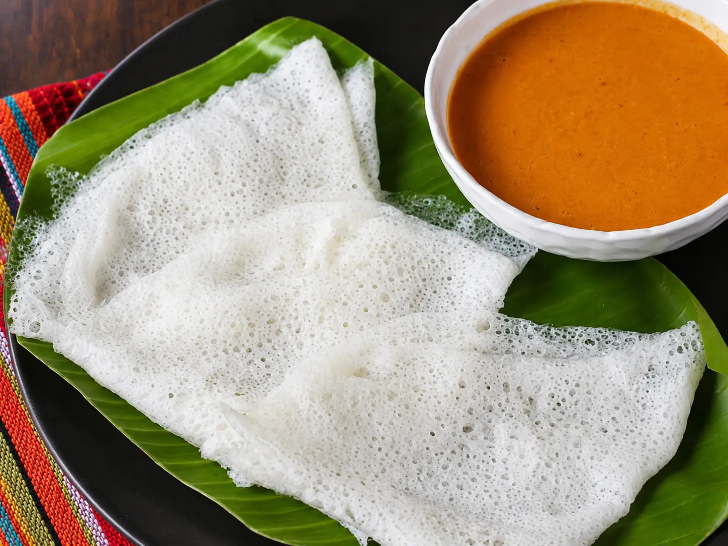 Soft, lacy white crepes folded neatly on a plate
